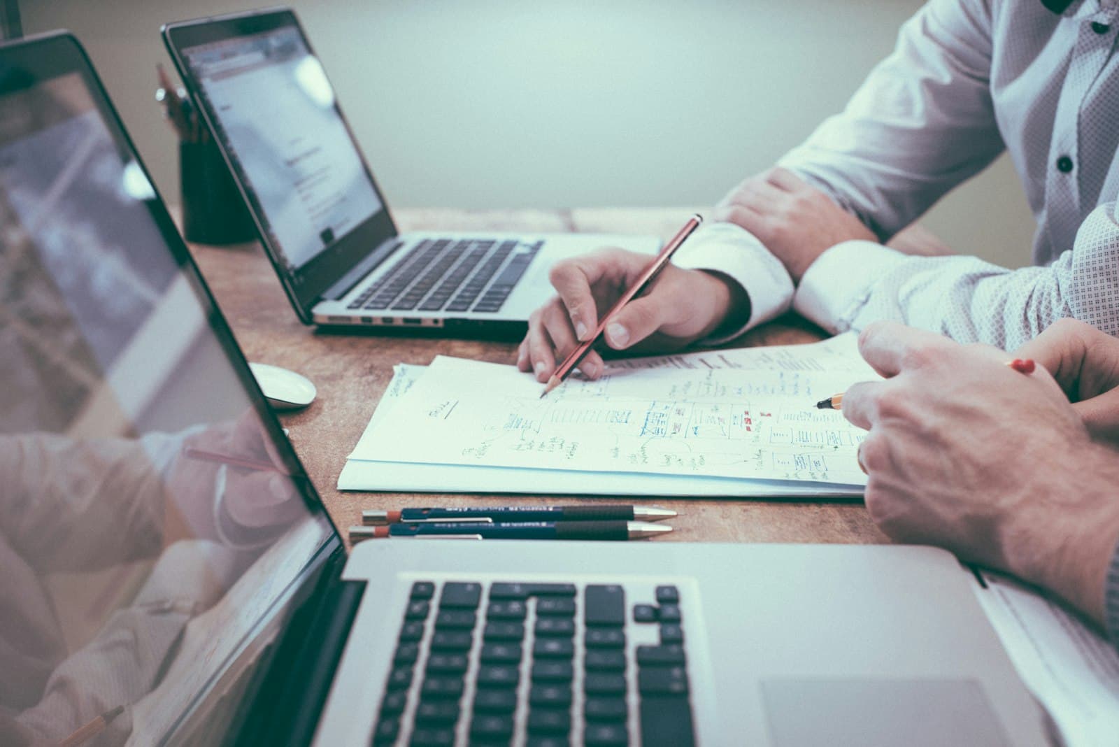 Two professionals sketching a strategy plan together at a desk — illustrating Blue Cap IT's consulting approach