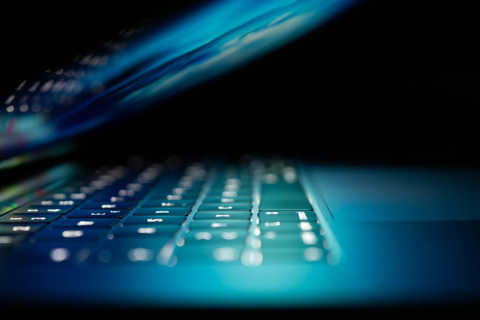Glowing blue laptop keyboard close-up