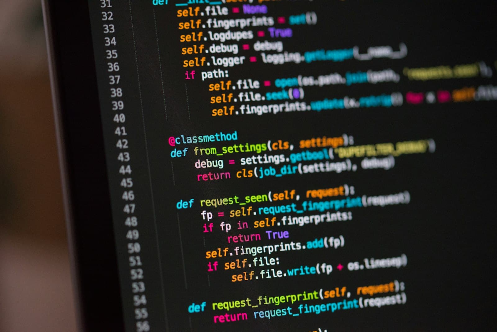 Lines of code displayed on a dark screen with colorful syntax highlighting — representing log analysis and threat hunting