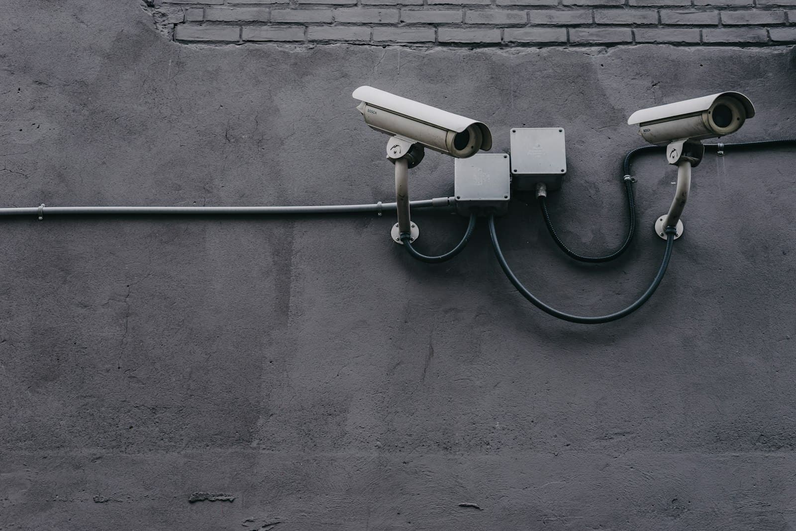 Two surveillance cameras mounted on a wall