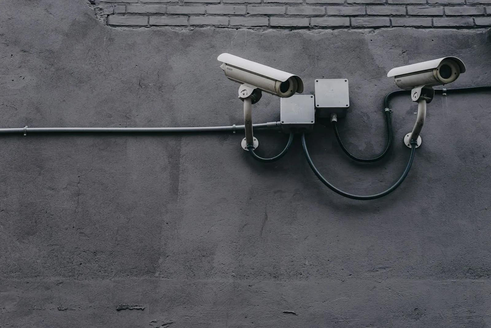 Two surveillance cameras mounted on a wall