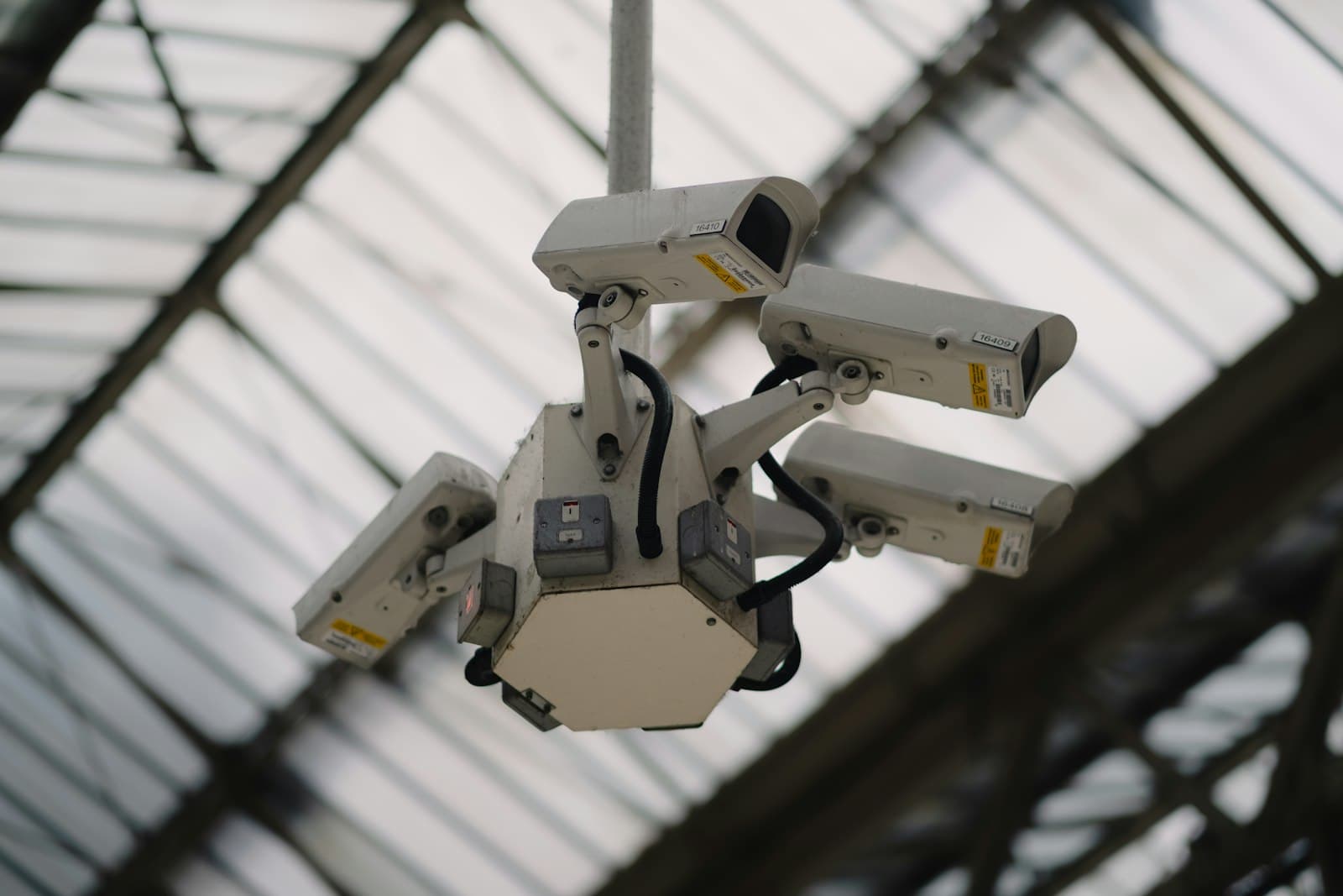 A grid of multiple surveillance cameras mounted on a ceiling — symbolizing AI-powered multi-camera intelligence
